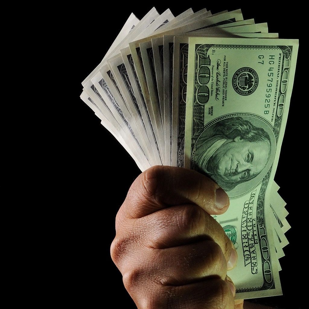 Hand holding US dollar bills